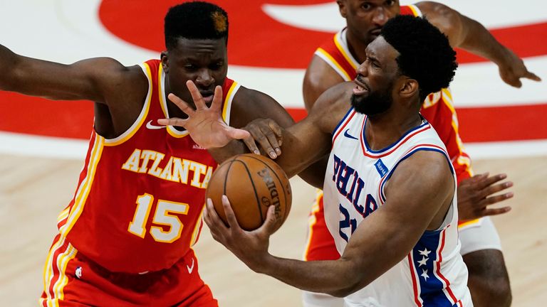 Philadelphia 76ers center Joel Embiid (21) clashes with Atlanta Hawks center Clint Capela (15) as Hawks forward Solomon Hill (18) looks on during the first half of Game 3 of a second-round NBA basketball playoff series, Friday, June 11, 2021, in Atlanta.