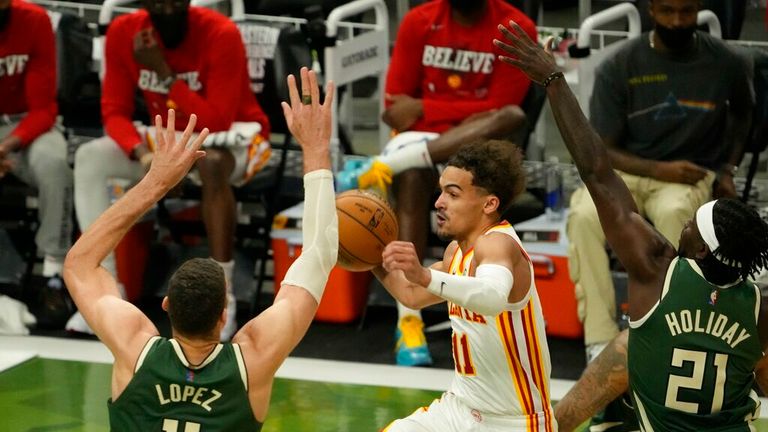 Atlanta Hawks&#39; Trae Young drives between Milwaukee Bucks&#39; Jrue Holiday and Brook Lopez during the first half of Game 1 of the NBA Eastern Conference basketball finals game Wednesday, June 23, 2021, in Milwaukee. (AP Photo/Morry Gash)


