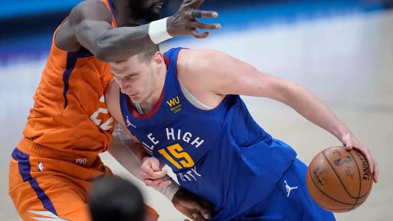 Denver Nuggets center Nikola Jokic drives as Phoenix Suns center Deandre Ayton defends during the second half of Game 3 of an NBA second-round playoff series Friday, June 11, 2021, in Denver. Phoenix won 116-102.