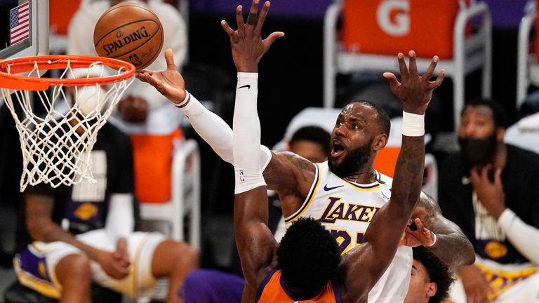 Los Angeles Lakers forward LeBron James, top, shoots as Phoenix Suns center Deandre Ayton defends during the second half in Game 4 of an NBA basketball first-round playoff series Sunday, May 30, 2021, in Los Angeles.
