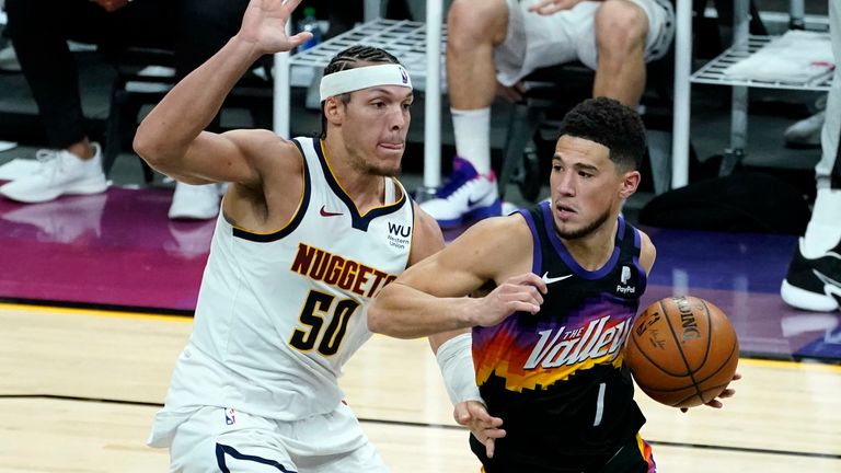 Phoenix Suns guard Devin Booker (1) drives as Denver Nuggets forward Aaron Gordon (50) defends during the second half of Game 1 of an NBA basketball second-round playoff series, Monday, June 7, 2021, in Phoenix.
