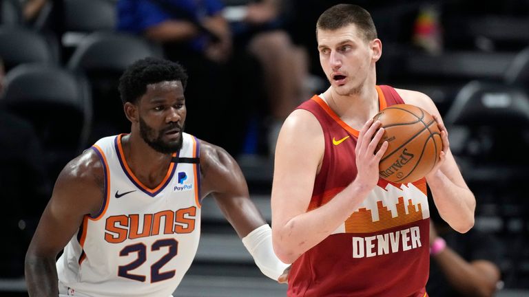 Denver Nuggets center Nikola Jokic, right, looks to pass the ball as Phoenix Suns center Deandre Ayton defends in the first half of Game 4 of an NBA second-round playoff series Sunday, June 13, 2021, in Denver.