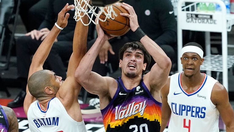 Phoenix Suns forward Dario Saric (20) shoots between Los Angeles Clippers forward Nicolas Batum (33) and guard Rajon Rondo (4) during the first half of Game 2 of the NBA basketball Western Conference Finals, Tuesday, June 22, 2021, in Phoenix. 