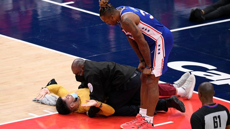 Philadelphia 76ers center Dwight Howard (39) watches as a fan who ran onto the court is restrained by security personnel during the second half of Game 4 in a first-round NBA basketball playoff series against the Washington Wizards, Monday, May 31, 2021, in Washington. 