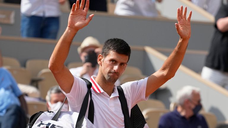 Novak Djokovic waves to the crowd after Italy&#39;s Lorenzo Musetti retired from the match in their fourth round match on day 9, of the French Open tennis tournament at Roland Garros in Paris, France, Monday, June 7, 2021. (AP Photo/Michel Euler)