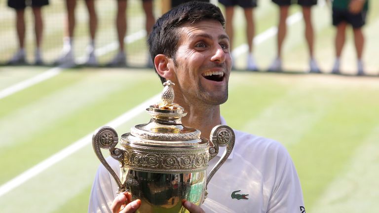 Serbia's Novak Djokovic holds the trophy after winning the men's singles final match against Kevin Anderson of South Africa, at the Wimbledon Tennis Championships, in London. 