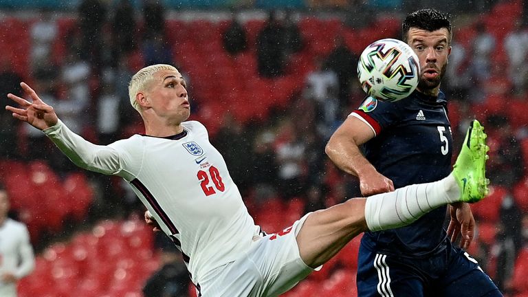 Phil Foden tries to control the ball under pressure from Grant Hanley during England vs Scotland