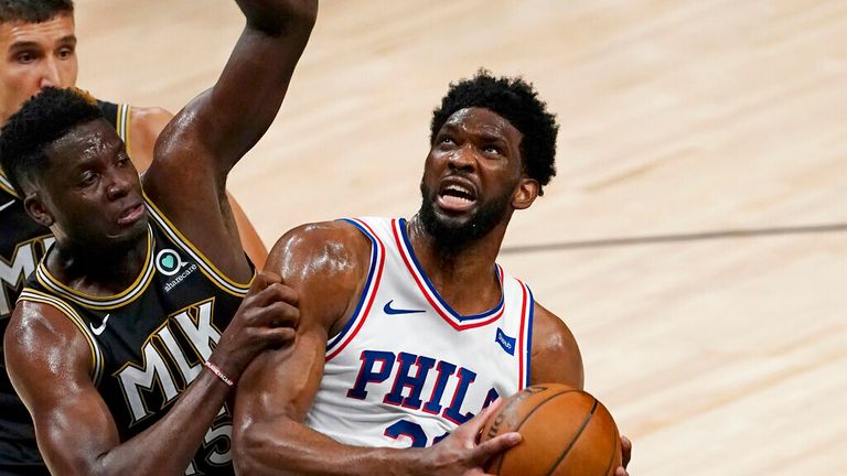 Philadelphia 76ers center Joel Embiid (21) is defended by Atlanta Hawks center Clint Capela (15) as he goes in for a basket during the first half of Game 6 of an NBA basketball Eastern Conference semifinal series Friday, June 18, 2021, in Atlanta. (AP Photo/John Bazemore)