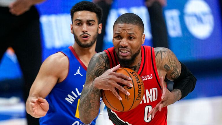 Portland Trail Blazers guard Damian Lillard (0) drives to the basket against Denver Nuggets guard Markus Howard during the second half of Game 5 of a first-round NBA basketball playoff series Tuesday, June 1, 2021, in Denver. (AP Photo/Jack Dempsey)