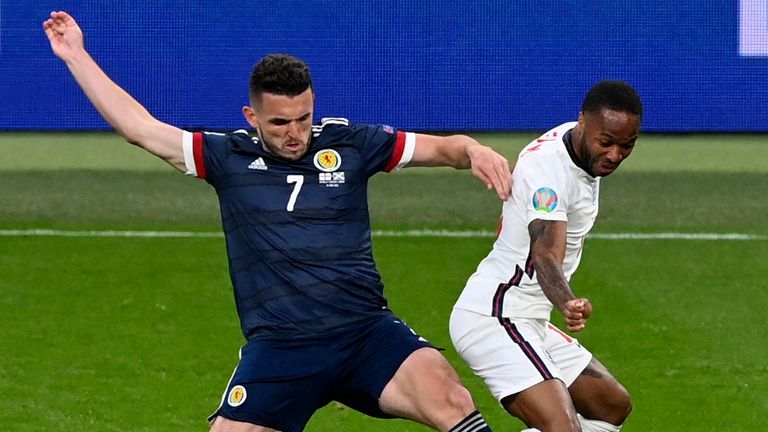 Raheem Sterling y John McGinn desafían el balón durante Inglaterra vs Escocia