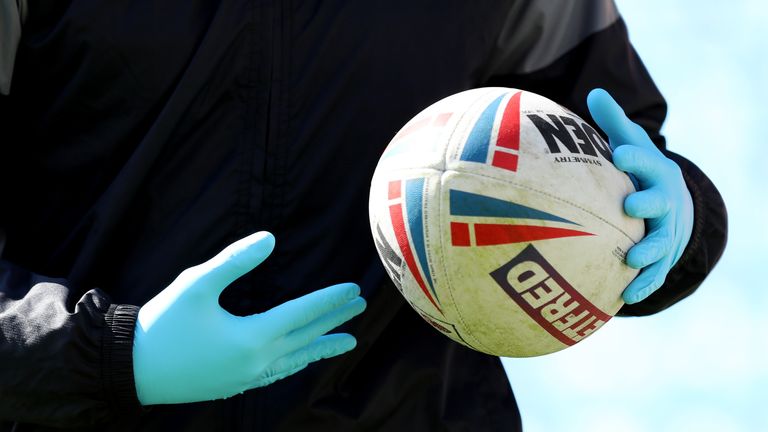 A detailed view of the Betfred Challenge Cup match ball held by a member of staff wearing medical gloves during the Betfred Challenge Cup match between Salford Red Devils and Widnes Vikings at AJ Bell Stadium on April 10, 2021 in Salford, England