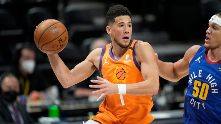 Phoenix Suns guard Devin Booker, left, passes the ball as Denver Nuggets forward Aaron Gordon defends during the first half of Game 3 of an NBA second-round playoff series Friday, June 11, 2021, in Denver. 
