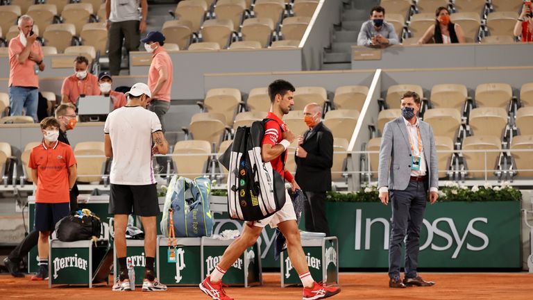 Novak Djokovic walks off the court as play is suspended with fans being made to leave the stadium due to government curfew restrictions 