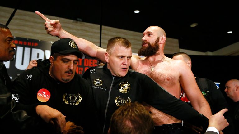 Boxer Tyson Fury, right, exchanges words with opponent Deontay Wilder, after facing each other at a news conference in Los Angeles Wednesday, Nov. 28, 2018, ahead of their heavyweight world championship boxing match on Dec. 1, at Staples Center in Los Angeles. (AP Photo/Damian Dovarganes)