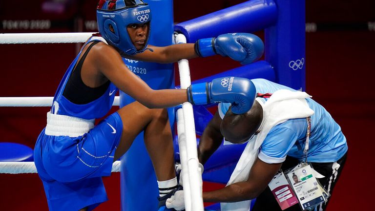 Keamogetse Sadie-Kenos do Botswana, à esquerda, tem seu sapato amarrado durante a luta de boxe de 57 kg feminino contra a britânica Kariss Artingstall nos Jogos Olímpicos de 2020, sábado, 24 de julho de 2021 em Tóquio, Japão.  (AP Photo / David Goldman) 