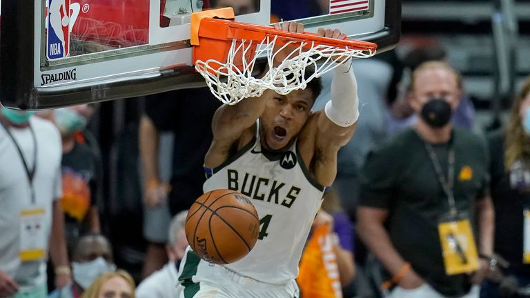 Milwaukee Bucks forward Giannis Antetokounmpo, top, dunks over Phoenix Suns guard Chris Paul during the second half of Game 5 of basketball&#39;s NBA Finals, Saturday, July 17, 2021, in Phoenix.