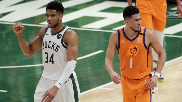 Milwaukee Bucks forward Giannis Antetokounmpo celebrates in front of Phoenix Suns guard Devin Booker at the end of Game 4 of basketball&#39;s NBA Finals