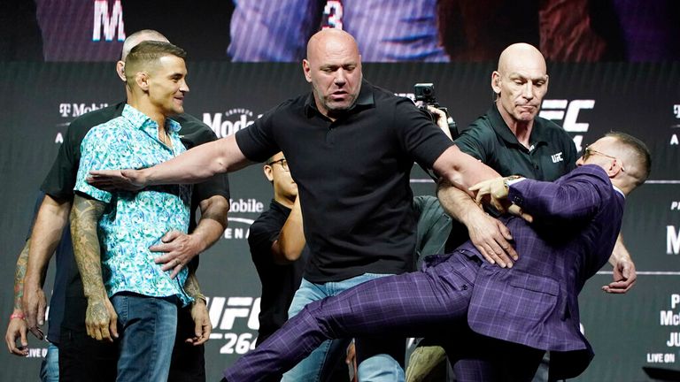 Conor McGregor, right, kicks at Dustin Poirier, left, as Dana White, UFC President, holds them apart during a news conference for a UFC 264 mixed martial arts bout Thursday, July 8, 2021, in Las Vegas. (AP Photo/John Locher)