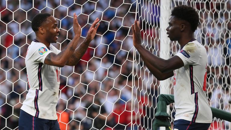 England's Raheem Sterling celebrates after scoring his side's opening goal with England's Bukayo Saka scores his side's opening goal during the Euro 2020 soccer semifinal match between England and Denmark at Wembley 