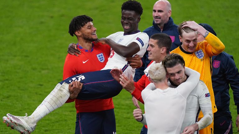 Tyrone Mings carries Bukayo Saka as they celebrate winning the Euro 2020 semi-final