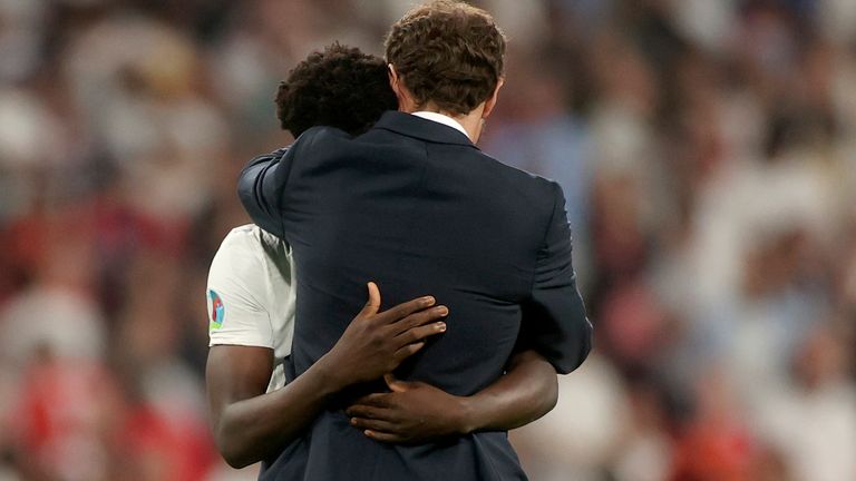 England's manager Gareth Southgate embraces Bukayo Saka after he failed to score a penalty during a penalty shootout after extra time during of the Euro 2020 soccer championship final match between England and Italy at Wembley 