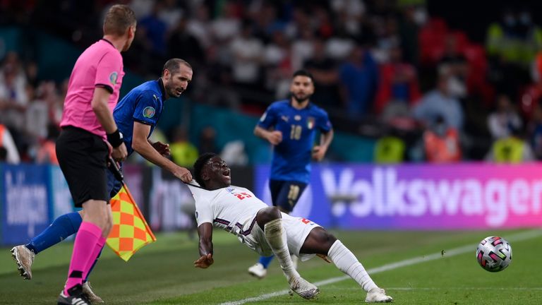 Italy's Giorgio Chiellini, left, stops England's Bukayo Saka during the Euro 2020 soccer final match between England and Italy at Wembley