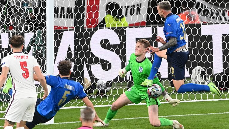 England's goalkeeper Jordan Pickford makes a save in front of Italy's Federico Bernardeschi during the Euro 2020 final soccer match between Italy and England at Wembley