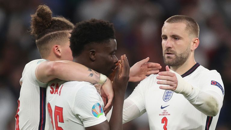 England's Kalvin Phillips and Luke Shaw comfort teammate Bukayo Saka after he failed to score a penalty during a penalty shootout after extra time during of the Euro 2020 soccer championship final match between England and Italy at Wembley