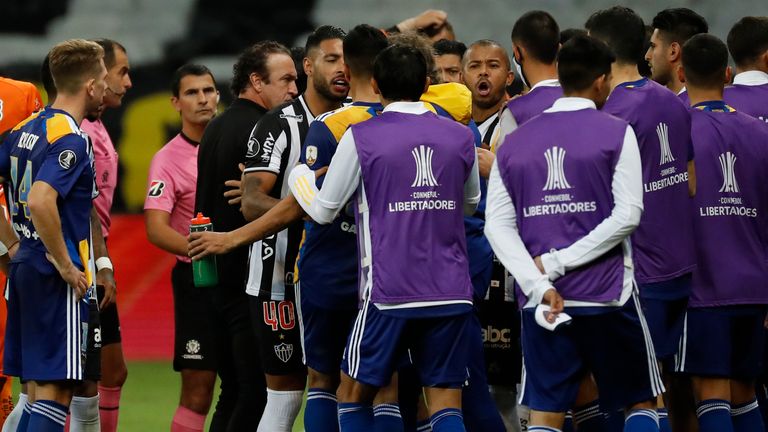Players of Boca Juniors and Atletico Mineiro argue as referee Esteban Ostojich checks the VAR system during a Copa Libertadores match
