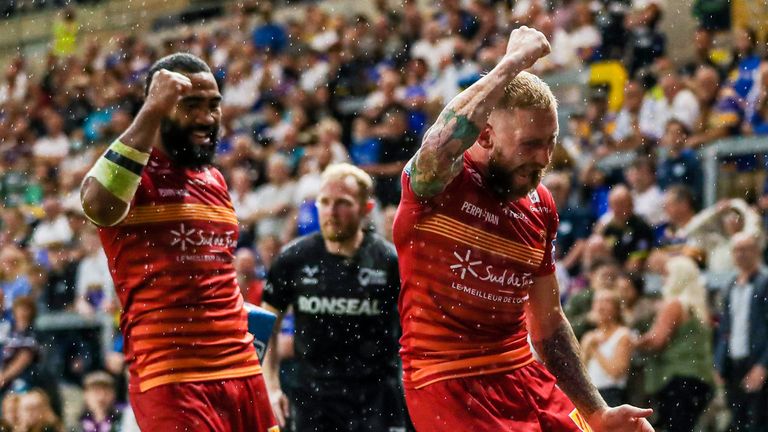 Catalans' Fouad Yaha is congratulated on their try by Sam Tomkins and Samisoni Langi.