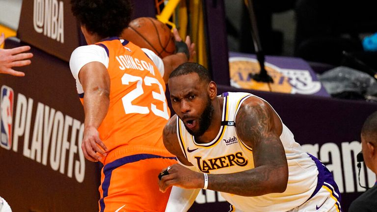 Los Angeles Lakers forward LeBron James, right, reacts after dunking as Phoenix Suns forward Cameron Johnson takes the ball during the first half in Game 4 of an NBA basketball first-round playoff series Sunday, May 30, 2021, in Los Angeles. (AP Photo/Mark J. Terrill)