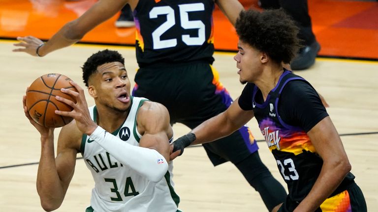 Milwaukee Bucks forward Giannis Antetokounmpo (34) looks to pass as Phoenix Suns forward Cameron Johnson (23)defends during the second half of Game 1 of basketball&#39;s NBA Finals, Tuesday, July 6, 2021, in Phoenix.