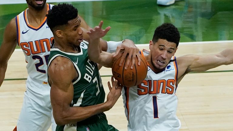 Milwaukee Bucks forward Giannis Antetokounmpo (34) and Phoenix Suns guard Devin Booker (1) battle for a loose ball during the second half of Game 3 of basketball&#39;s NBA Finals in Milwaukee, Sunday, July 11, 2021.
