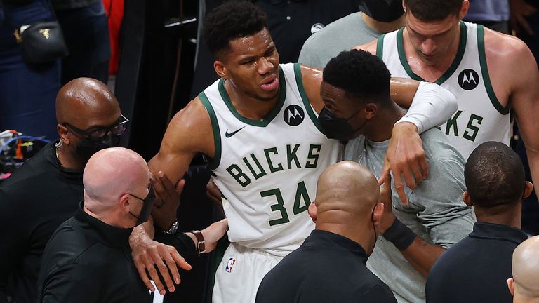 Giannis Antetokounmpo is helped off the court after injuring his left knee against the Atlanta Hawks