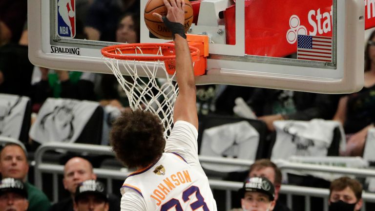 Phoenix Suns&#39; Cameron Johnson (23) dunks as he&#39;s fouled by Milwaukee Bucks&#39; P.J. Tucker (17) during the second half of Game 3 of basketball&#39;s NBA Finals, Sunday, July 11, 2021, in Milwaukee. 