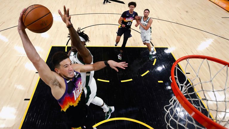 Phoenix Suns&#39; Devin Booker goes up for a dunk next to Milwaukee Bucks&#39; Jrue Holiday (21) during the first half of Game 2 of basketball&#39;s NBA Finals, Thursday, July 8, 2021, in Phoenix. (Christian Petersen/Pool Photo via AP)


