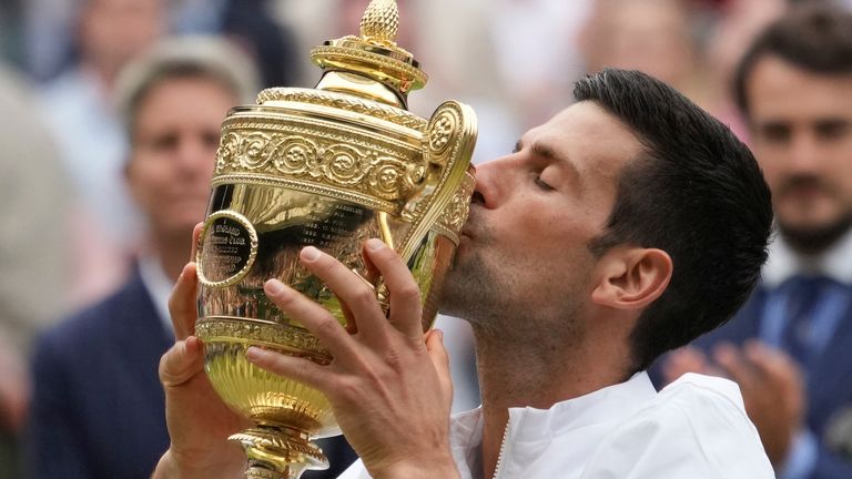 Novak Djokovic kisses the trophy after winning sixth Wimbledon title and a 20th Grand Slam title of his career