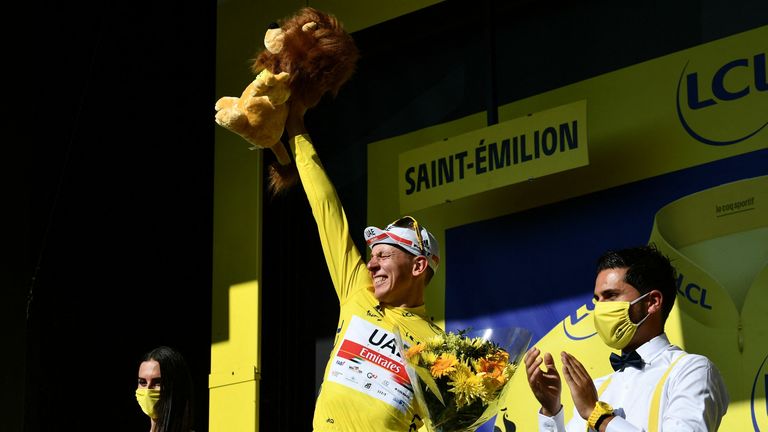 Team UAE Emirates' Pogacar celebrates his overall leader yellow jersey on the podium at the end of the 20th stage. 