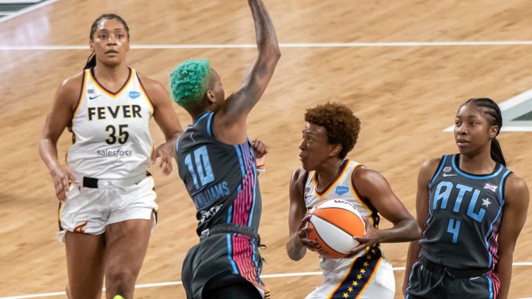 Indiana Fever guard Danielle Robinson (3) drives between Atlanta Dream guards Aari McDonald (4) and Courtney Williams (10) during a WNBA basketball game, Sunday, July 11, 2021, in College Park, Ga.