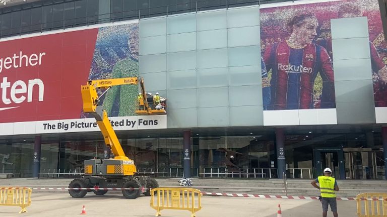  Los trabajadores del Barcelona retiran una enorme imagen de su exjugador Lionel Messi del lateral del Camp Nou.