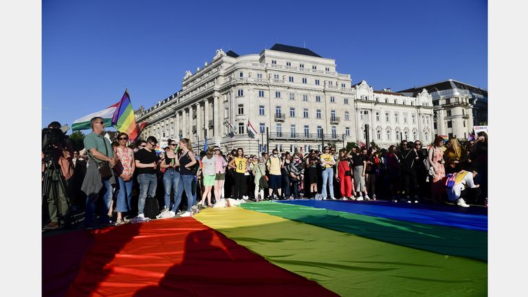 People unfurl a rainbow flag during an LGBT rights demonstration in front of the Hungarian Parliament building in Budapest, Hungary on June. 14, 2021.