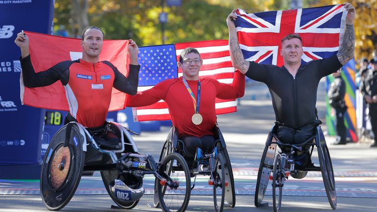 Second place finisher Marcel Hug of Switzerland, left, first place finisher Daniel Romanchuk of the United States, center, and third place finisher David Weir of Great Britain pose for a picture at the finish line of the New York City Marathon in New York, Sunday, Nov. 4, 2018
