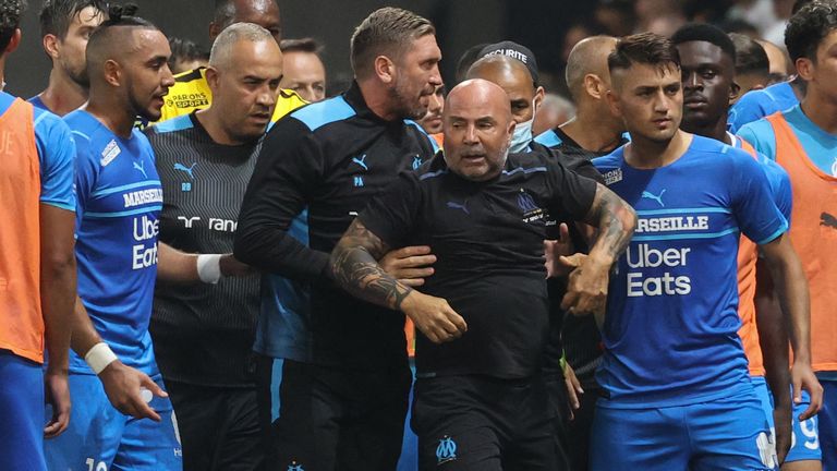 Marseille's French midfielder Dimitri Payet gestures as head coach Jorge Sampaoli is held by a colleague