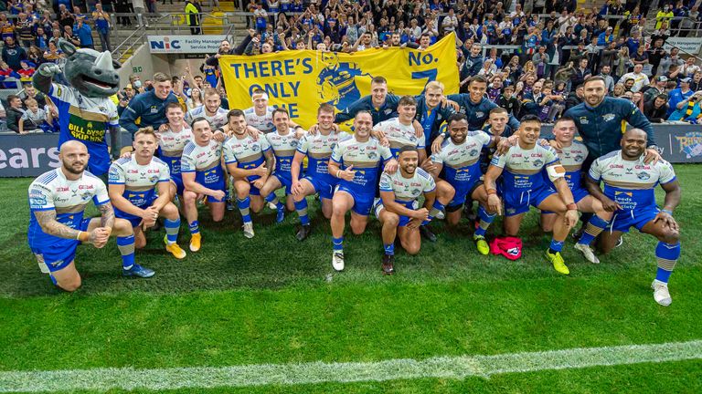 Leeds's gather in front of their fans and a Rob Burrow banner after victory over Huddersfield.