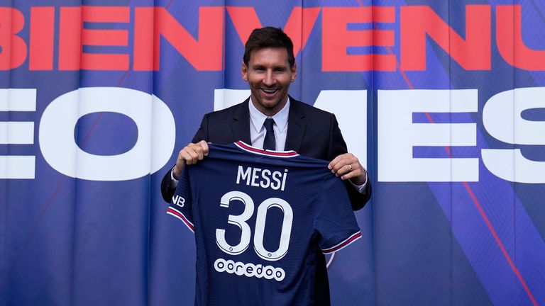 Lionel Messi pictured holding his PSG jersey after a press conference