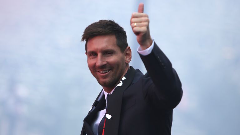 Lionel Messi gestures to the PSG supporters gather outside the Parc des Princes