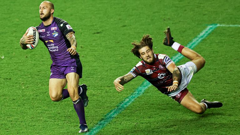 Picture by Paul Currie/SWpix.com - 25/08/2021 - Rugby League - Betfred Super League Round 21 - Wigan Warriors v Leeds Rhinos - DW Stadium, Wigan, England - Leeds Rhinos' Luke Briscoe avoids the tackle of Joe Shorrocks of Wigan Warriors