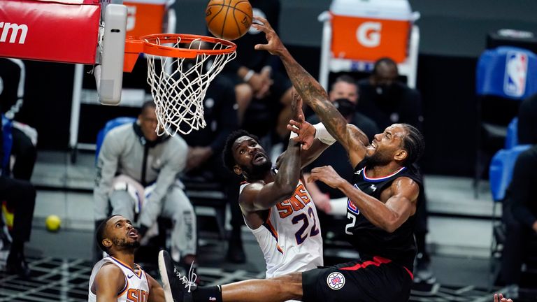 Los Angeles Clippers forward Kawhi Leonard, right, dunks over Phoenix Suns center Deandre Ayton (22) during the second half of an NBA basketball game Thursday, April 8, 2021, in Los Angeles.