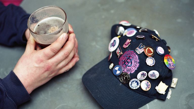 SOCIALISER - A Dulwich Hamlet fan pictured with a pint of beer and a cap adorned in pin badges

ORIGINAL CAPTION - Two hands holding a pint next to a Dulwich Hamlet baseball cap covered with football pin badges ahead of the Dulwich Hamlet game against Truro City on the 16th March 2019 at Champion Hill in South London in the United Kingdom.(photo by Sam Mellish / In Pictures via Getty Images)