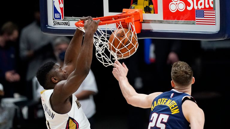 New Orleans Pelicans forward Zion Williamson, left, dunks the ball for a basket as Denver Nuggets center Isaiah Hartenstein defends in the first half of an NBA basketball game Sunday, March 21, 2021, in Denver.